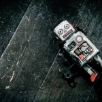 sad beat up old retro robot on a wooden floor shot from above